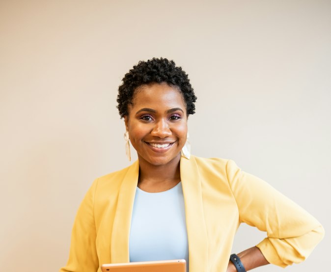 Femme souriante tenant une tablette