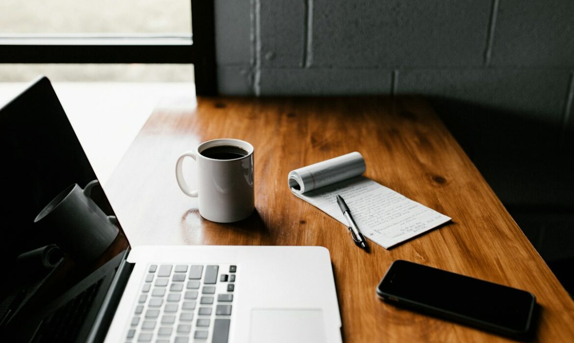 Ordinateur portable, tasse et carnet sur un bureau