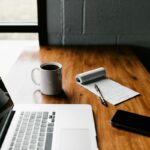 Ordinateur portable, tasse et carnet sur un bureau