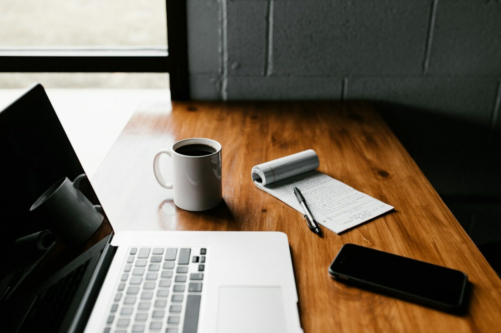 Ordinateur portable, tasse et carnet sur un bureau