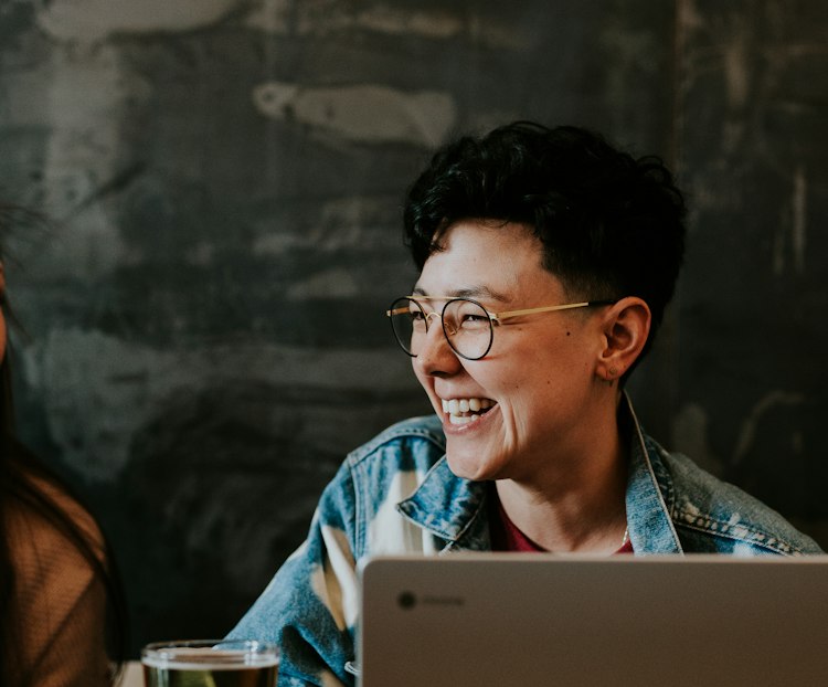 Personne souriante travaillant sur un ordinateur portable