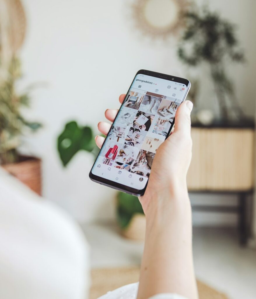 Main tenant un smartphone affichant un fil Instagram