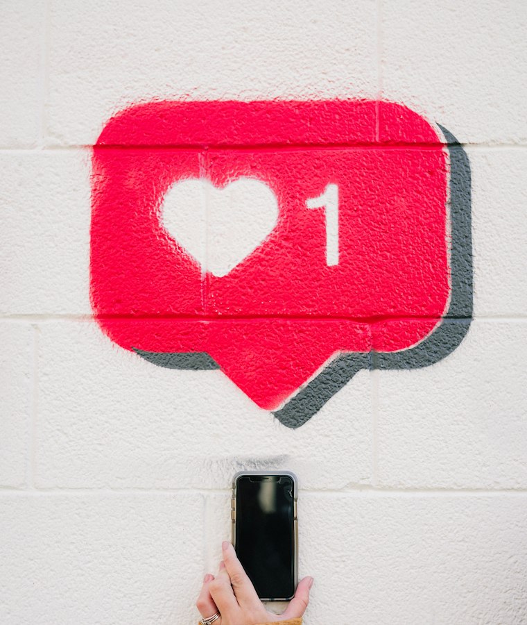 Smartphone et icône de like sur un mur